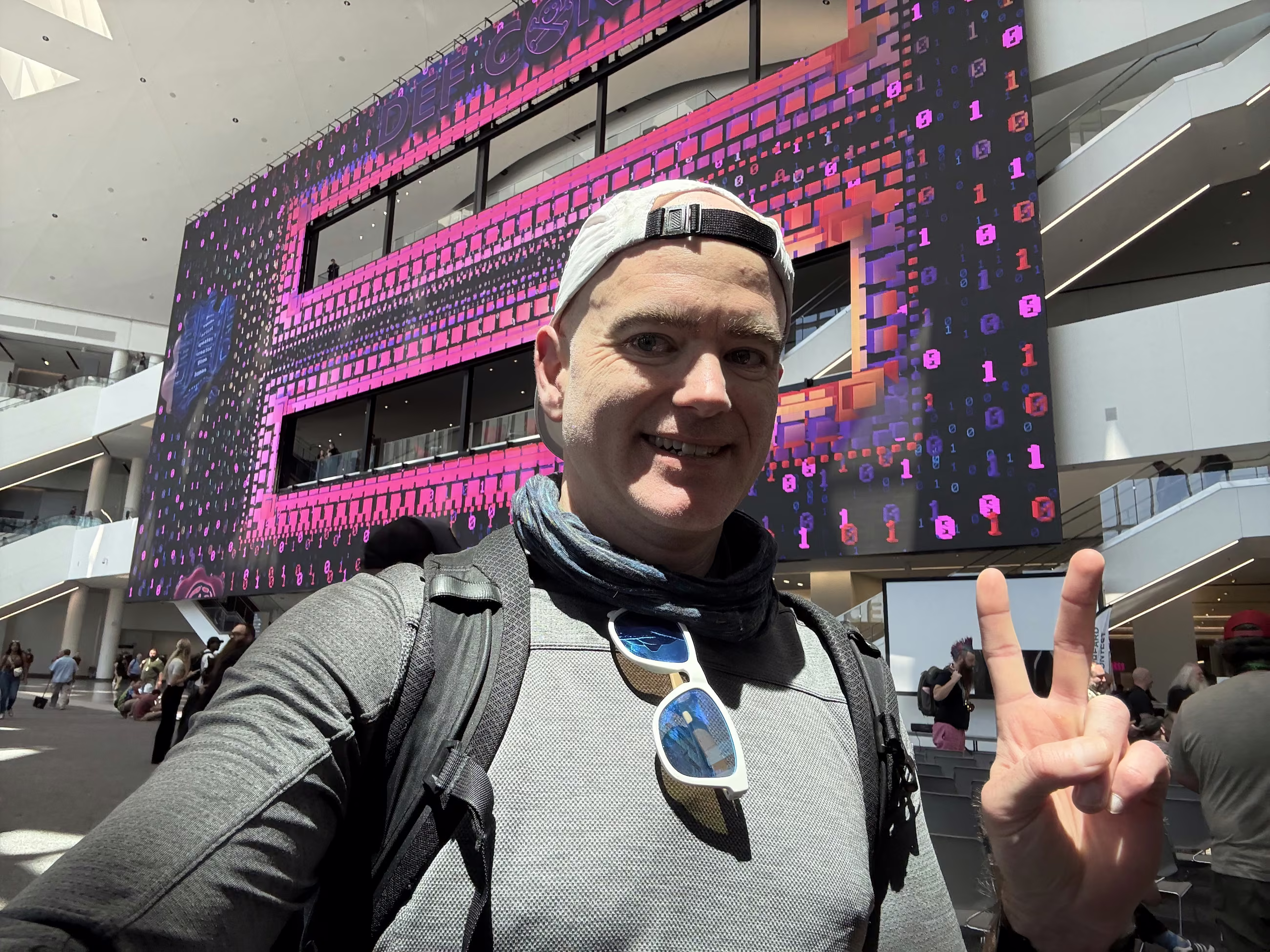 Selfie in front of the giant DEF CON 33 pixel-art wall
