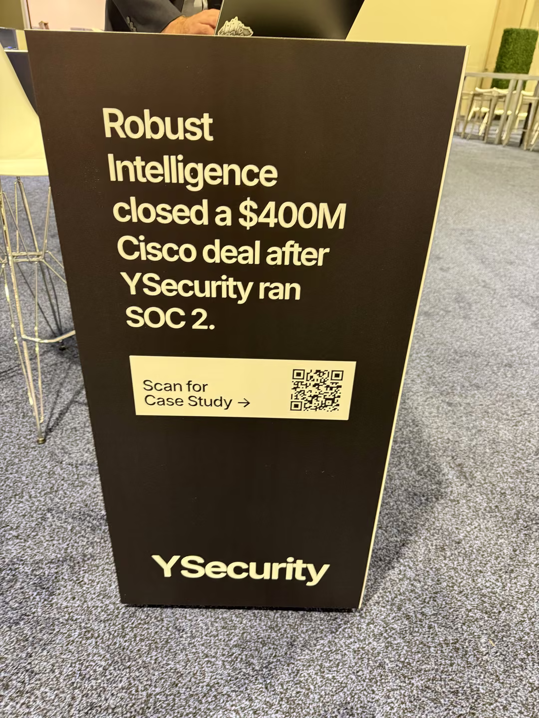 YSecurity booth sign at the Gartner Security and Risk Management Summit reading: Robust Intelligence closed a $400M Cisco deal after YSecurity ran SOC 2